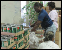 Haven volunteers help unpack canned goods.