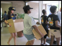 Navy Shipmates carry boxes out for delivery to our oldest clients.