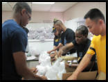 Navy Shipmates help bag up food.