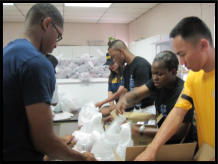 Navy Shipmates help bag up food.