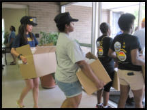 Navy Shipmates carry boxes out for delivery to our oldest clients.